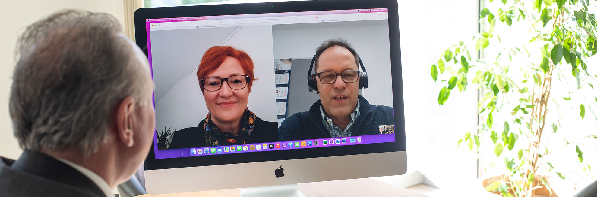 Ihre Digitale Kanzlei Ein Mann sitzt vor einem Computer und führt eine Online-Konferenz